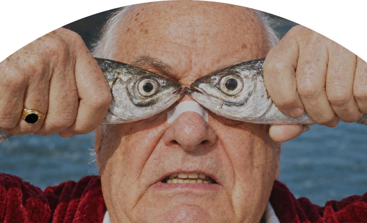 Klaus segurando dois peixes diante dos olhos